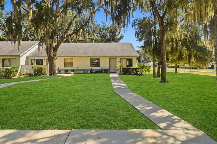 front view of townhouse and front yard with walk up sidewalk from parking spot