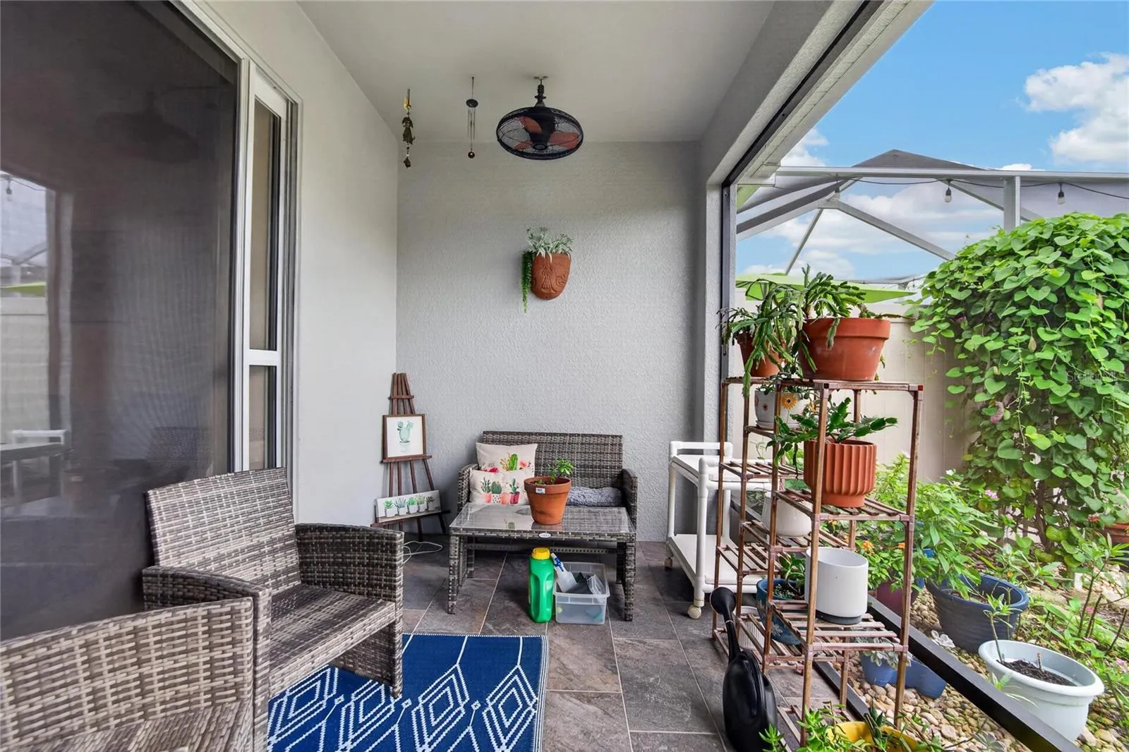 The screened lanai creates a peaceful outdoor retreat with room to sit, unwind and enjoy the garden view