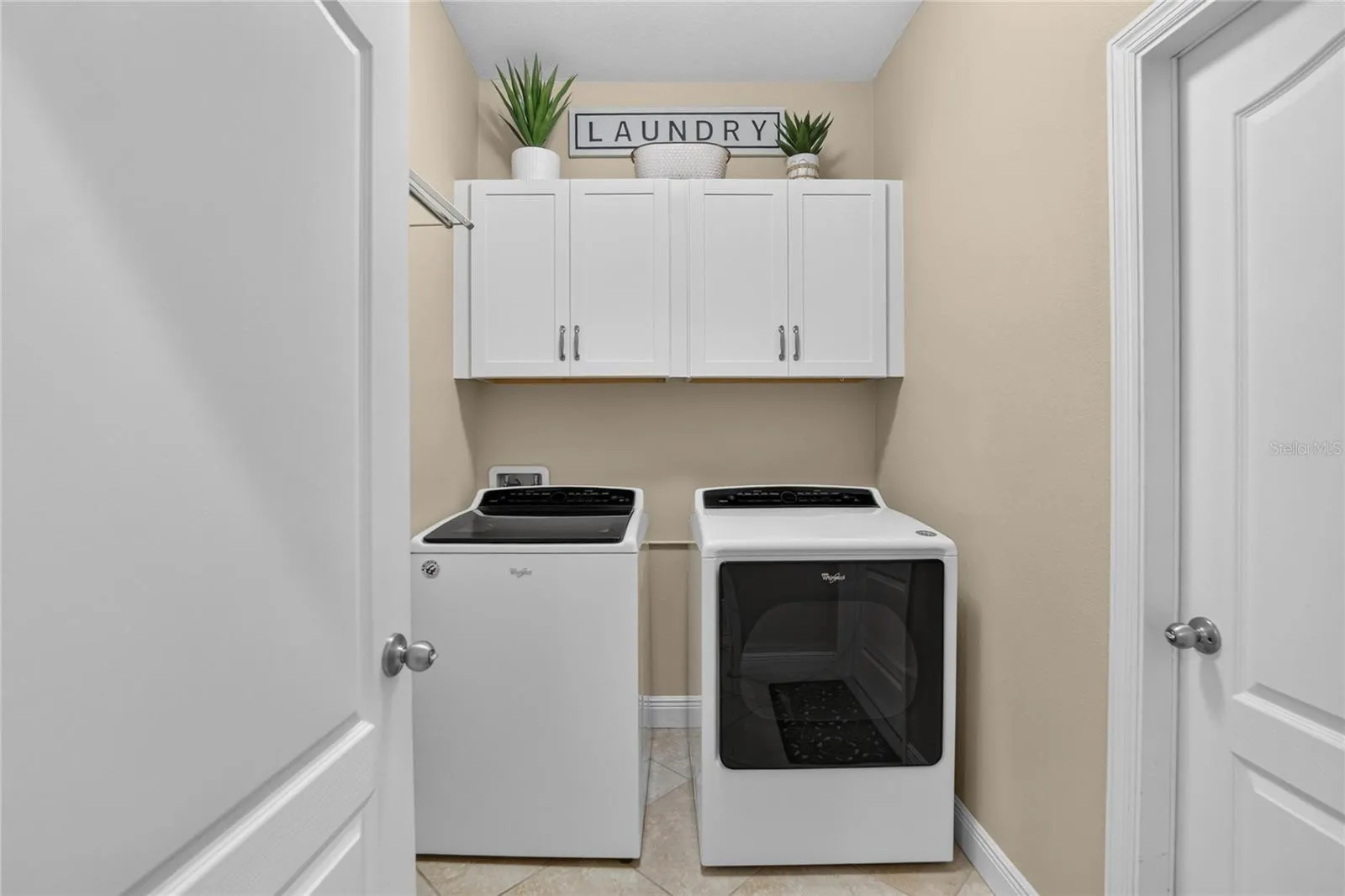 Added upper cabinets make laundry day easier by keeping supplies organized and everyday clutter tucked away