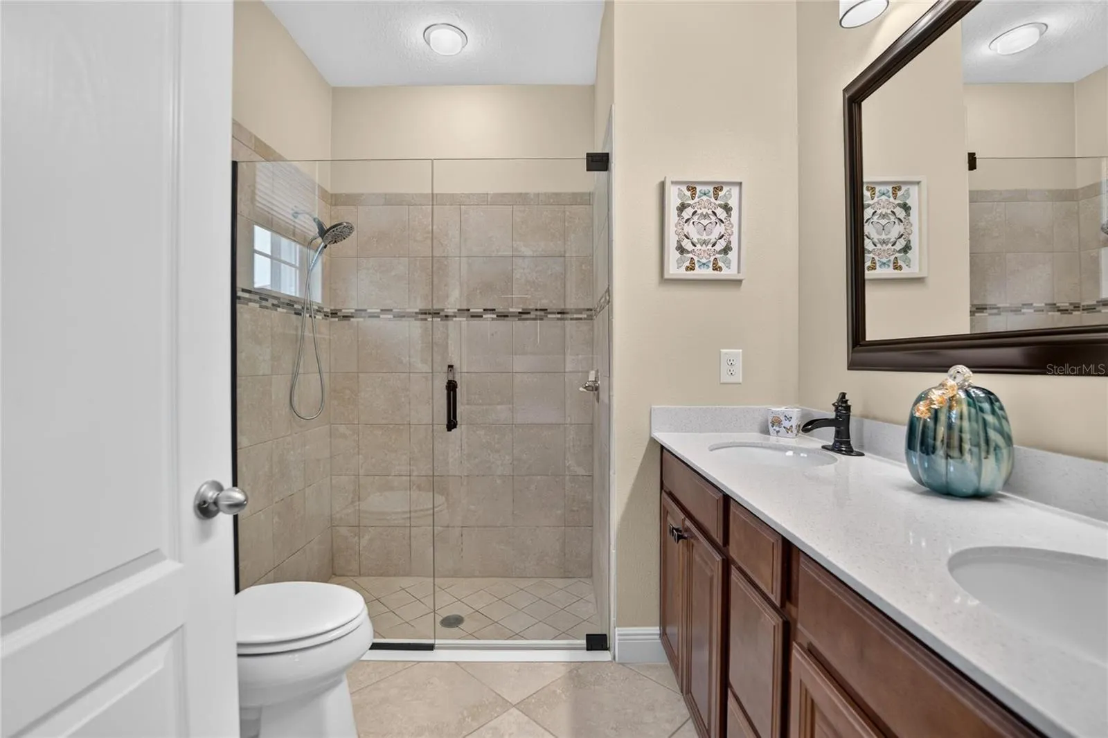 The refreshed primary bath features an easy entry tiled shower and upgraded details chosen beyond the builder standard