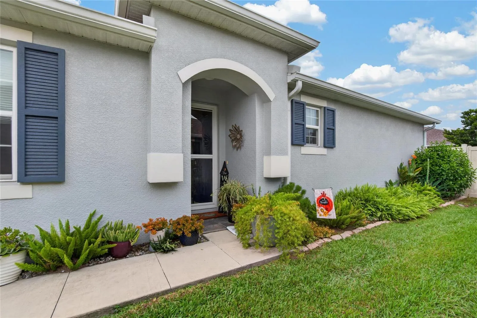A covered entrance and established landscaping offer a warm welcome before you ever step inside