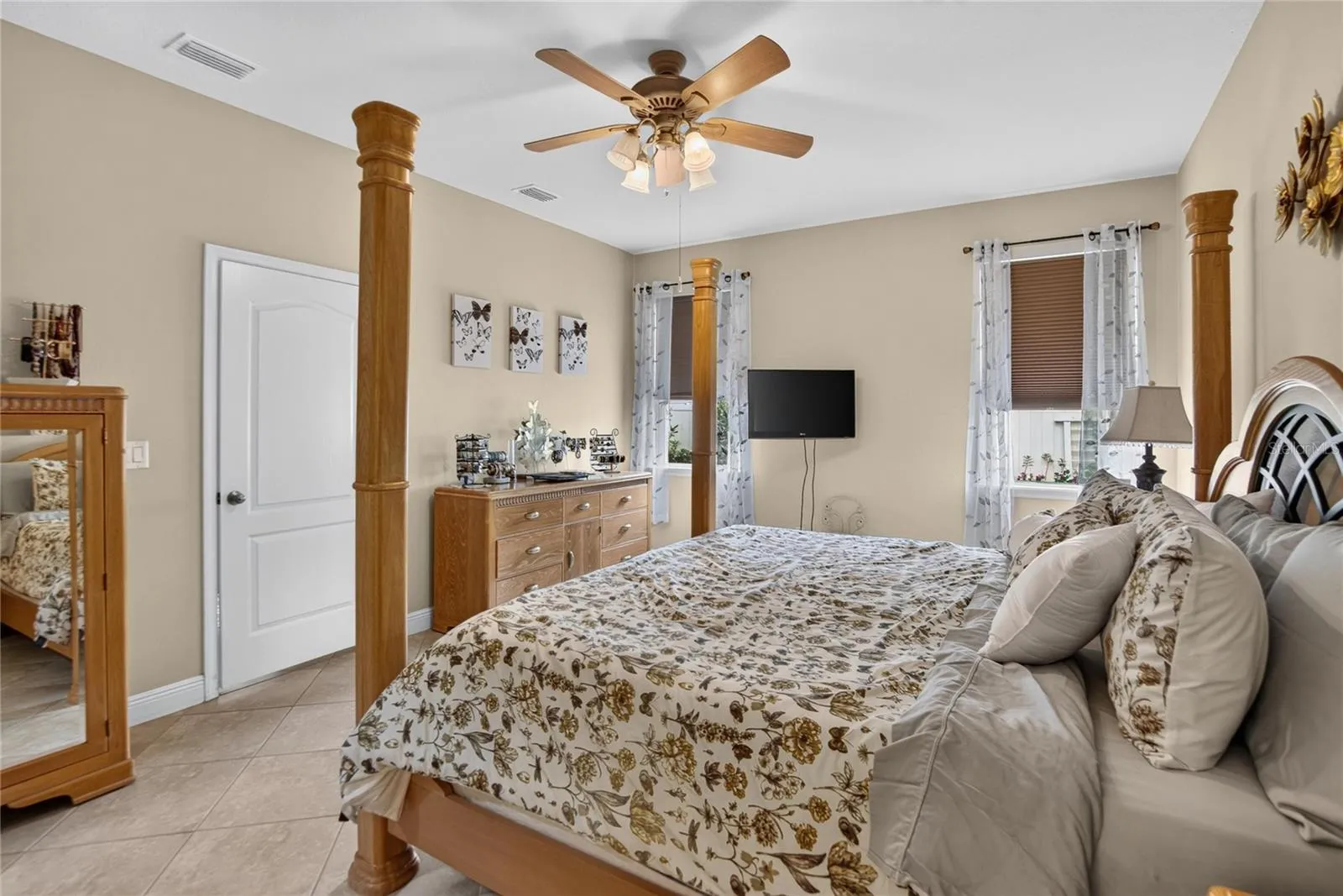 Multiple windows welcome natural light into the primary bedroom while preserving a calm, comfortable atmosphere