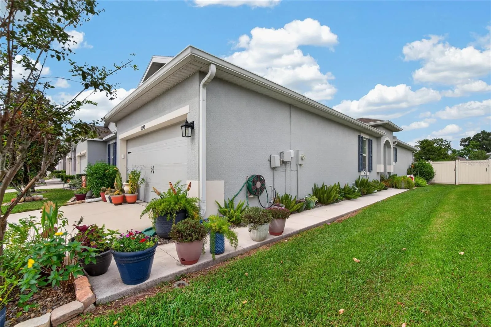 The landscaped side walkway provides convenient fenced yard access and another view of the maintained exterior
