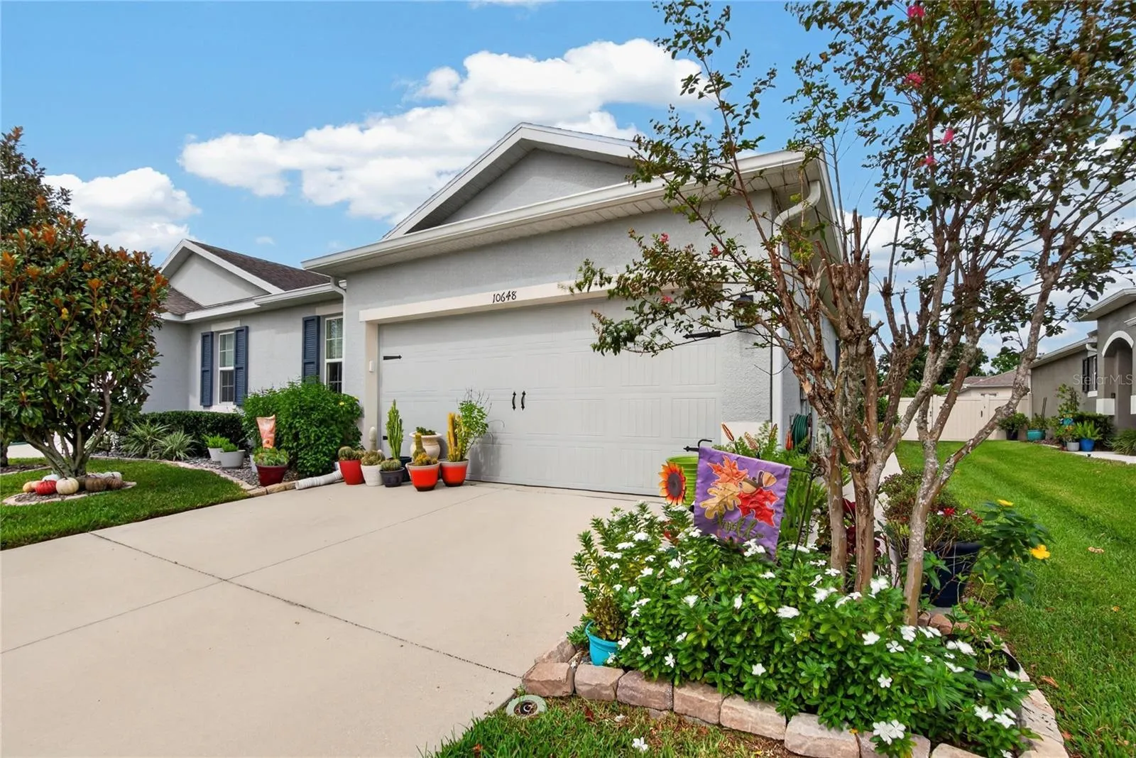 A colorful landscaped approach frames the home and gives buyers a warm sense of arrival.