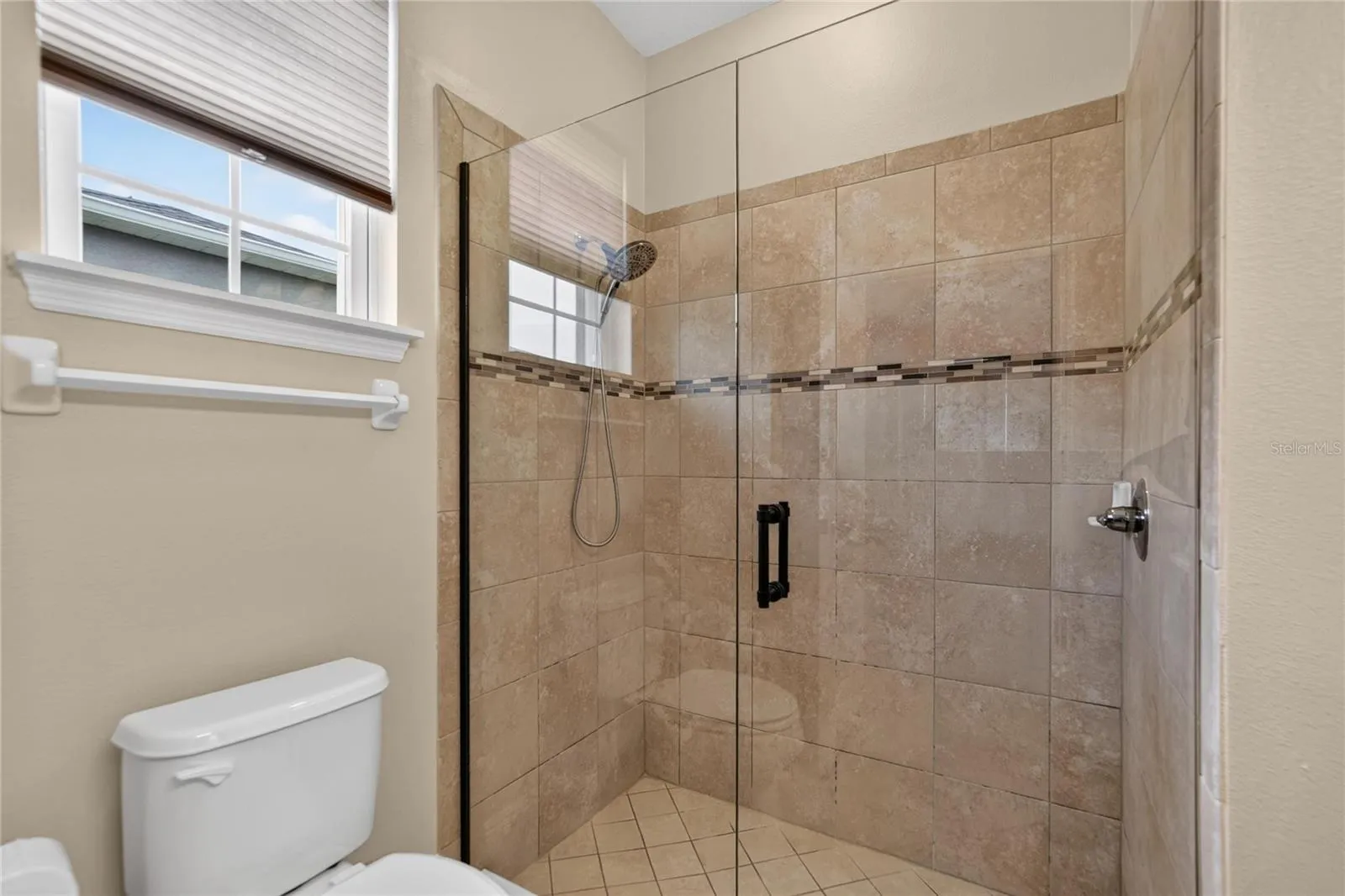 Natural light and an easy entry tiled shower help the primary bath feel bright, open and comfortable