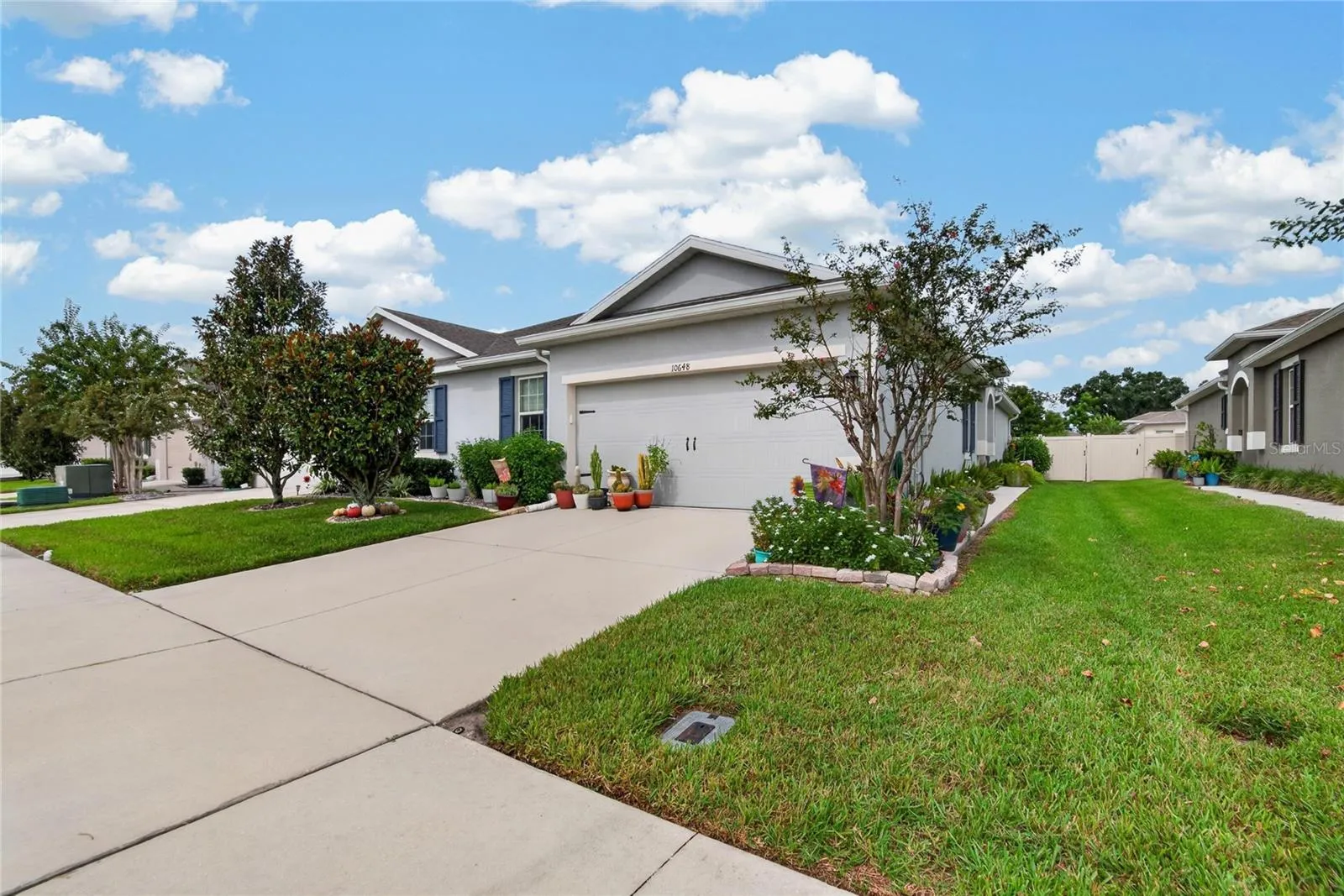 A wide three quarter view shows the home’s full approach, driveway and well maintained front lawn.