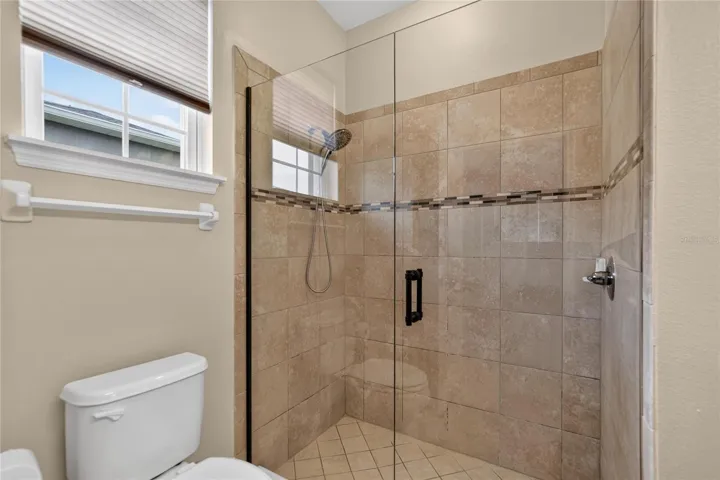 Natural light and an easy entry tiled shower help the primary bath feel bright, open and comfortable