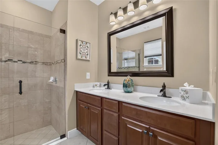 Updated lighting, mirror and waterfall style faucets give the dual vanity a polished, custom finished look