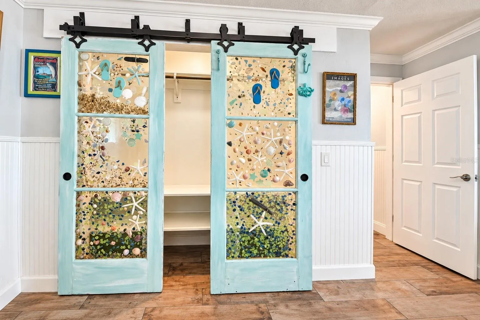 Primary bedroom closet with custom glass barn doors.