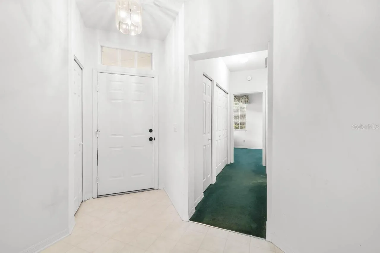 Entry way from inside the front door and view of hallway to guest bath and guest bedroom