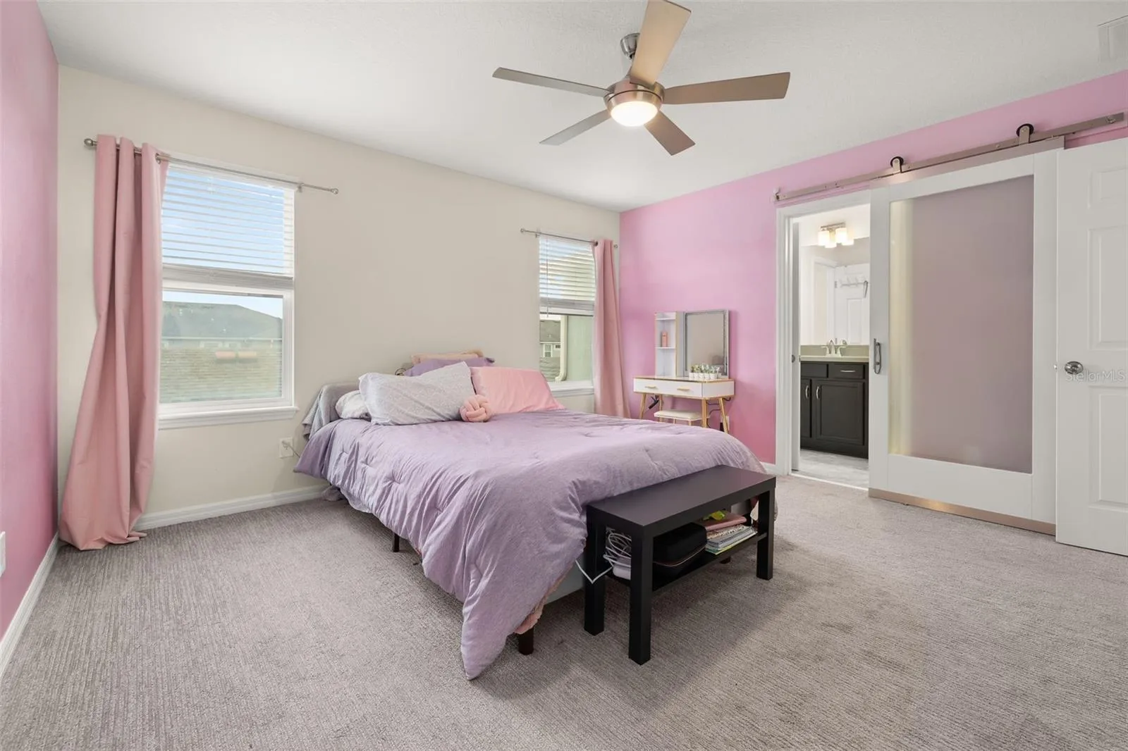 Primary suite with a custom barn door leading to the primary bathroom