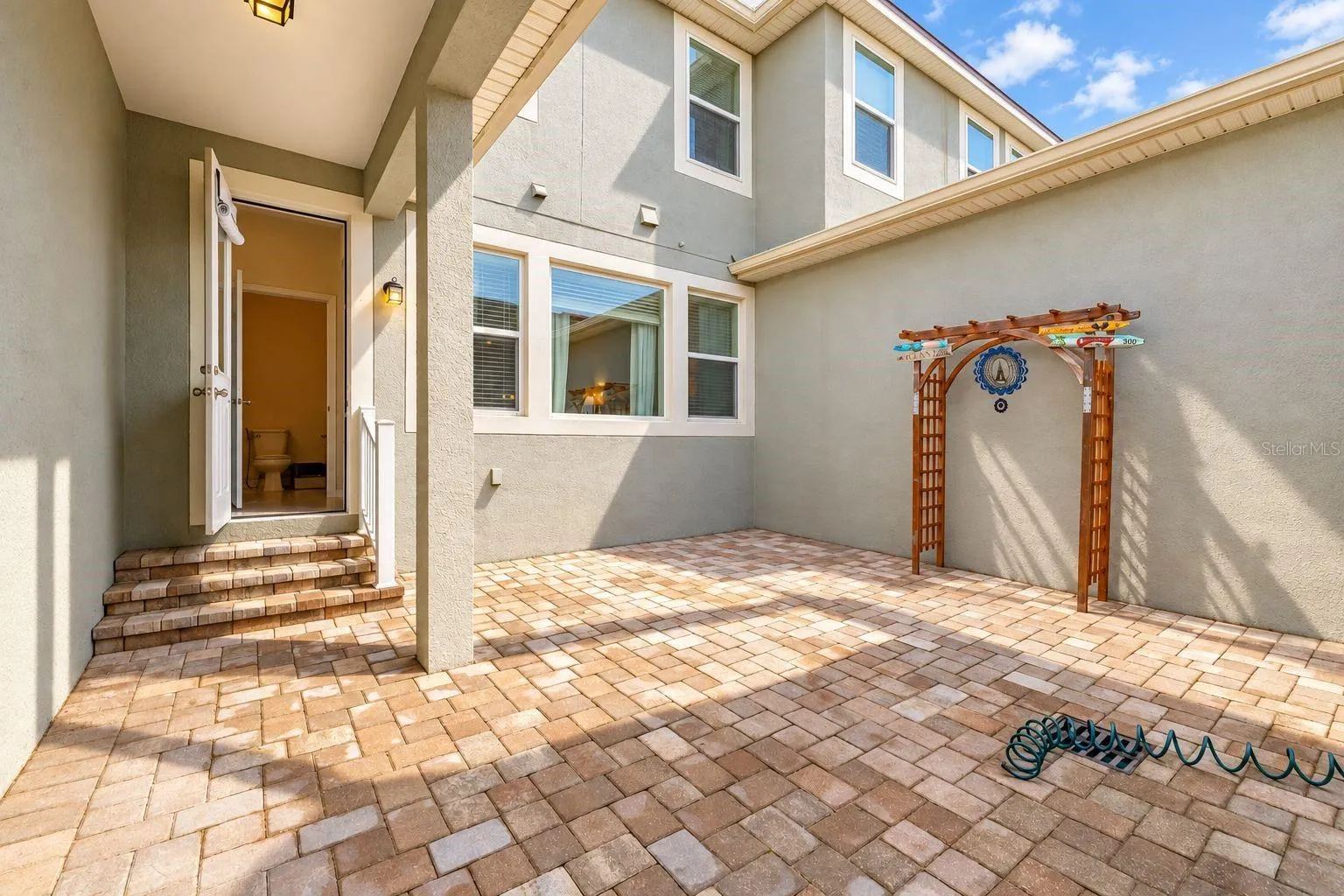 Private brick-paved courtyard between the house and the 2-car garage