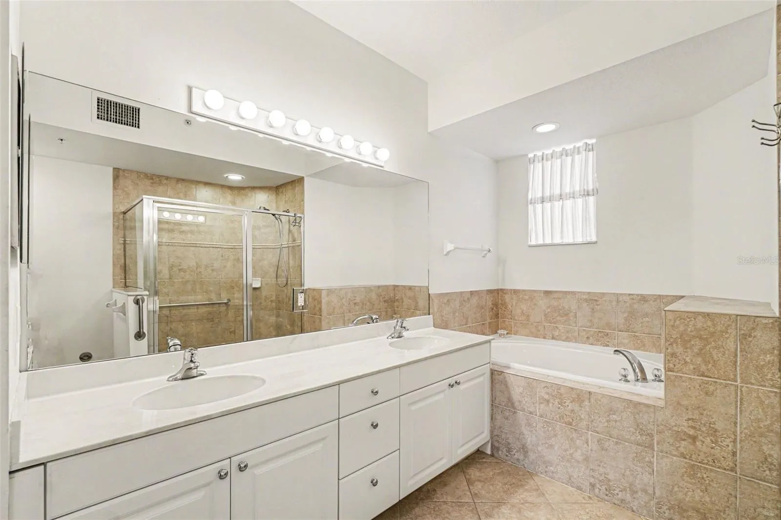 Primary Bathroom with dual sink vanity, soaking tub and walk in shower.