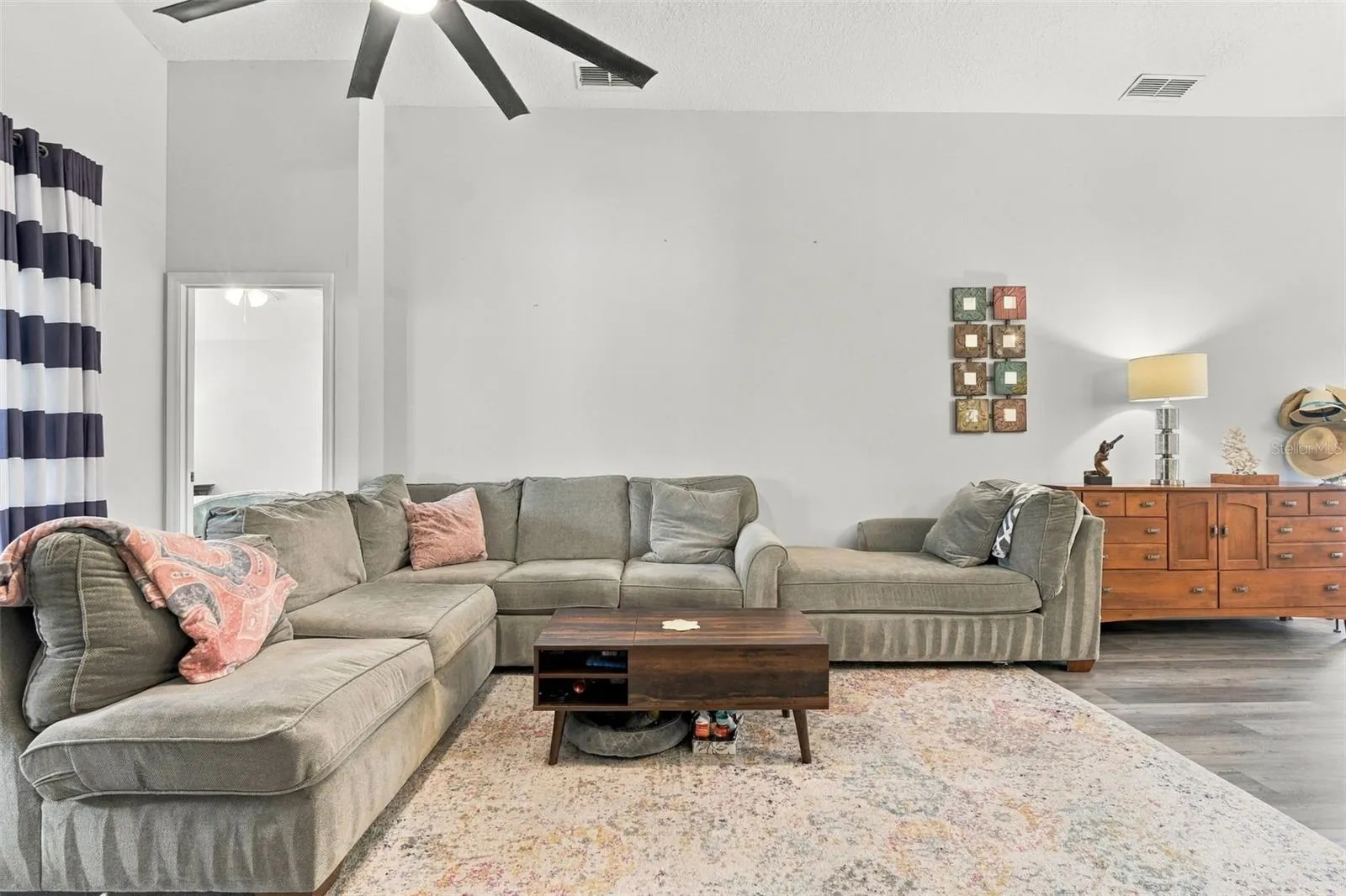 Main living area w/large sliding doors at left. Primary bedroom suite afar.