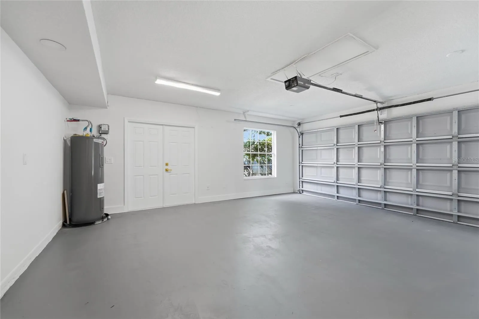 Spacious garage with generous parking space, windows for natural light, and a dedicated exit door.