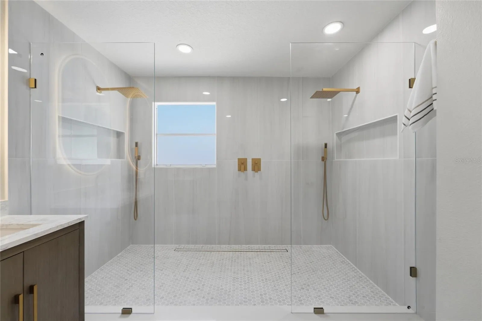 Oversized walk-in shower with largeporcelain tile and dual rainfall heads