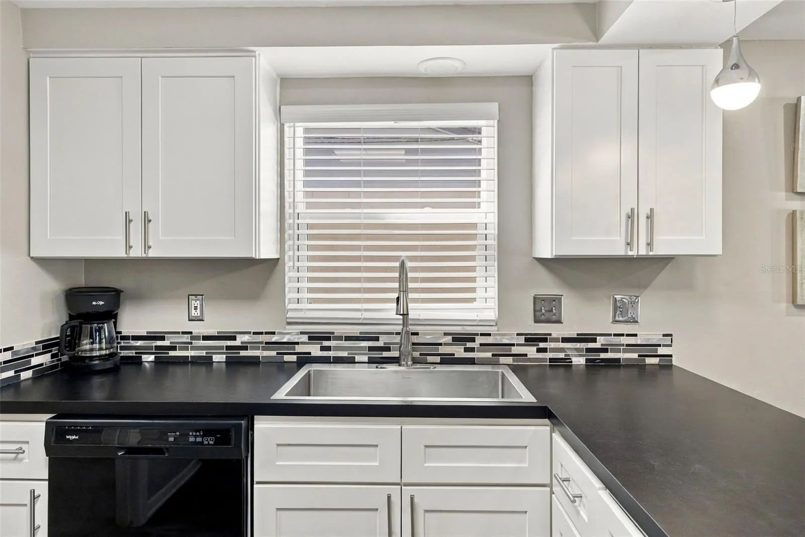 Large Farm-style sink with new faucet and glass-tile backsplash