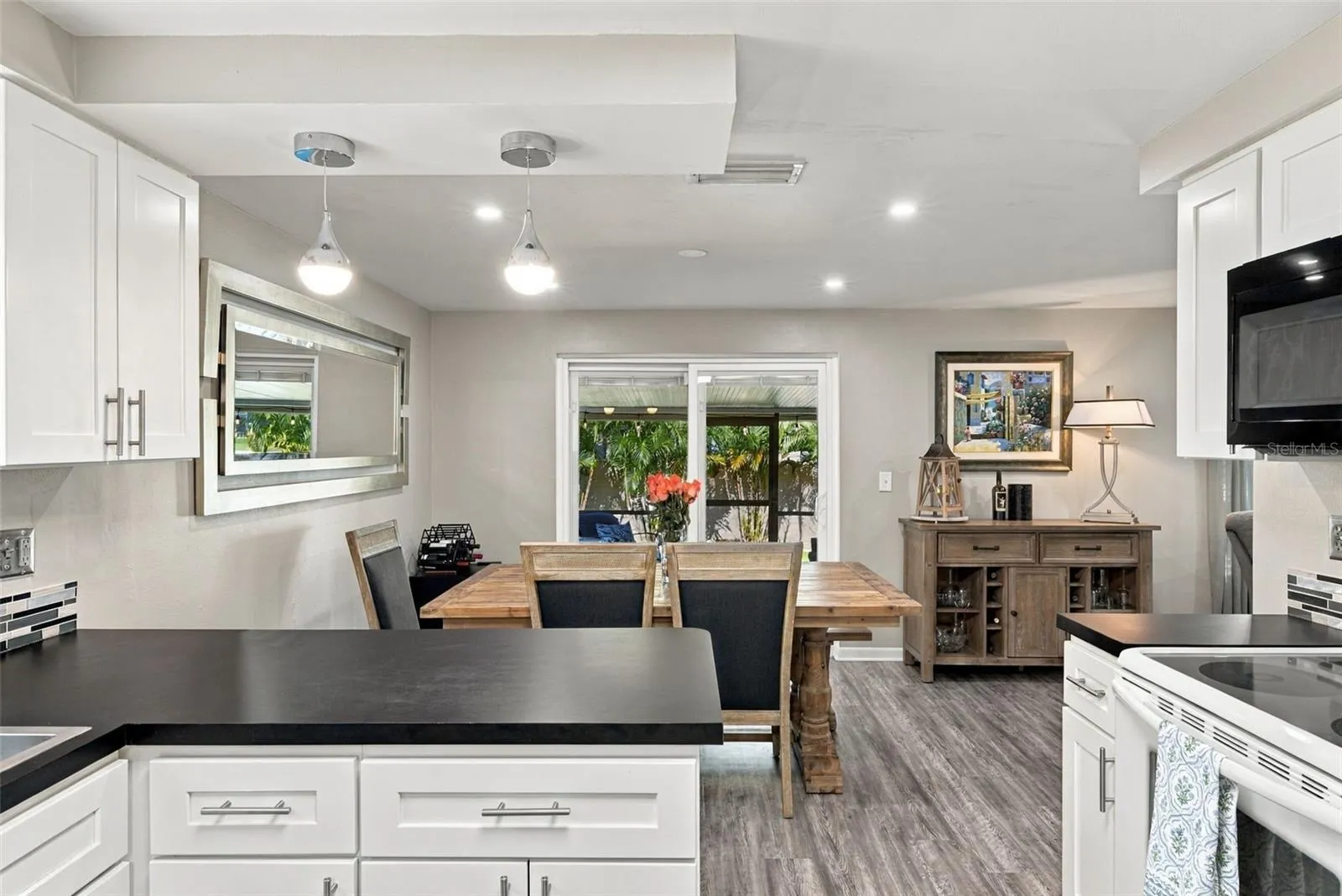 Kitchen to dining room with view of large cov. lanai and lovely backyard.