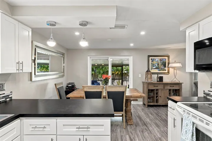 Kitchen to dining room with view of large cov. lanai and lovely backyard.
