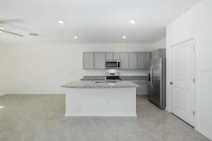 Crisp gray shaker-style cabinetry pairs beautifully with granite countertops and stainless-steel appliances for a fresh, contemporary feel