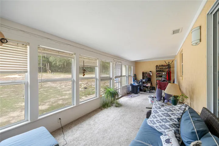 SUNROOM LOOKING TO PAST KITCHEN PASS-THRU WINDOW TO INSIDE LAUNDRY ROOM