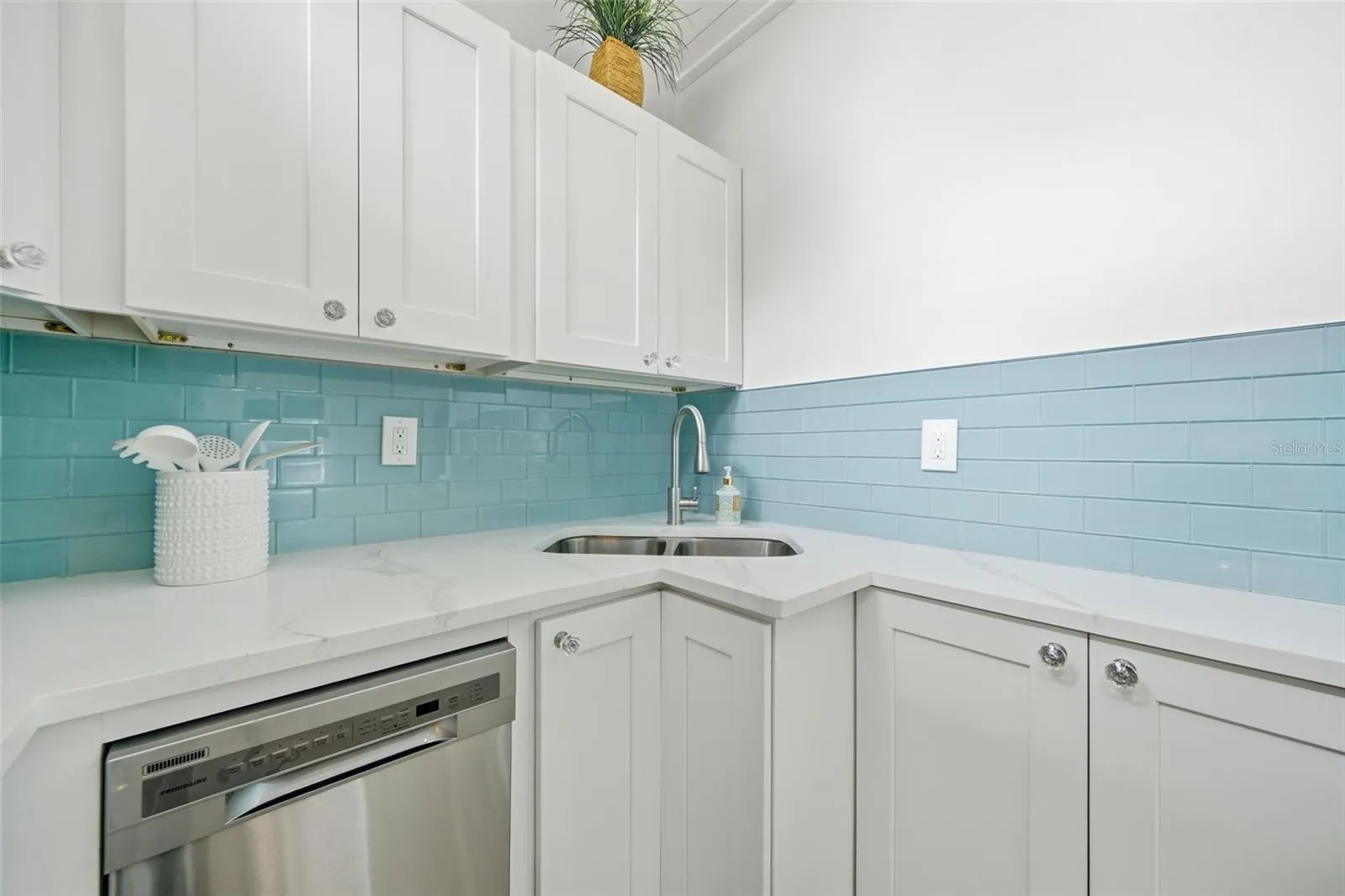 Shaker cabinets, dishwasher and seaglass backsplash