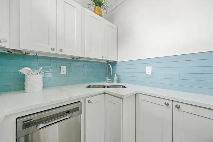 Shaker cabinets, dishwasher and seaglass backsplash