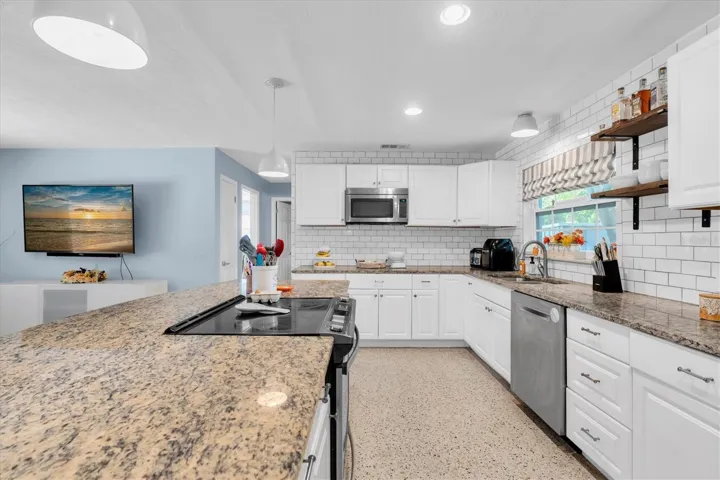 Updated kitchen with shaker-style cabinetry and granite counters