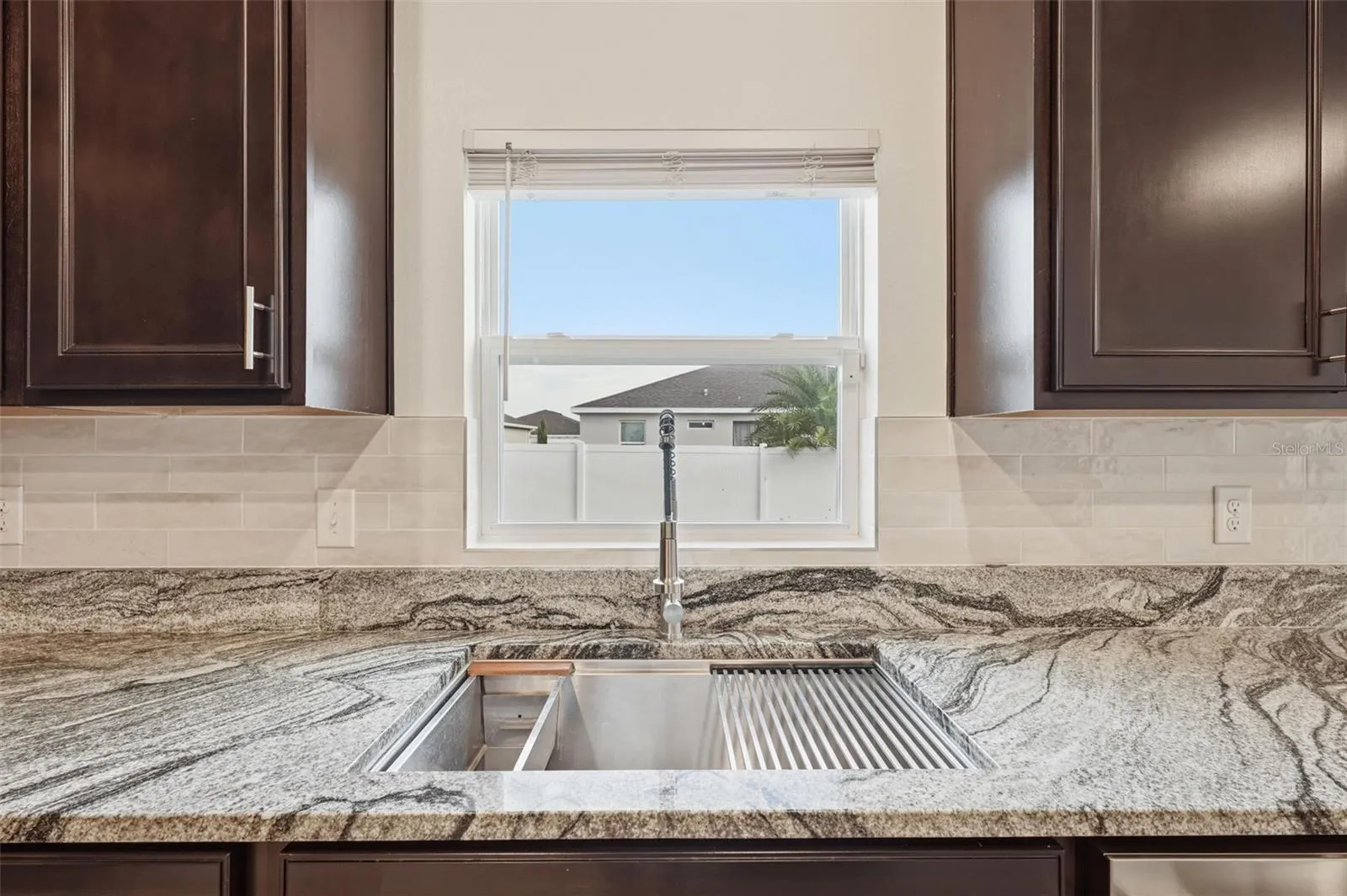 Large single basin, stainless steel sink with Granite counters and new tile backsplash