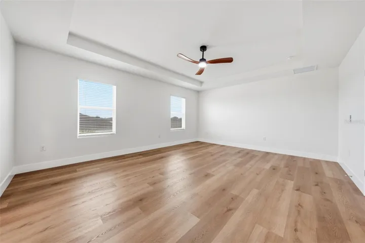 Spacious primary bedroom with tray ceiling