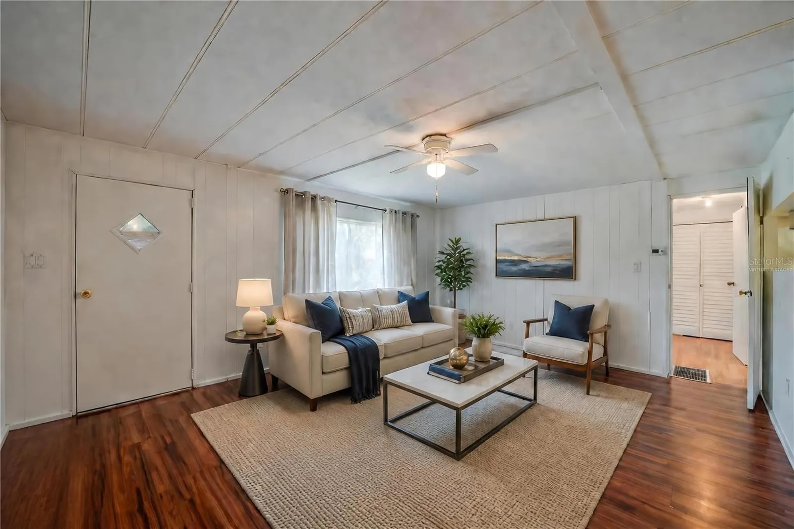 Virtually Staged - Expansive living room offers plenty of flexibility for multiple furniture arrangements, along with a ceiling fan and a large window overlooking the exterior.