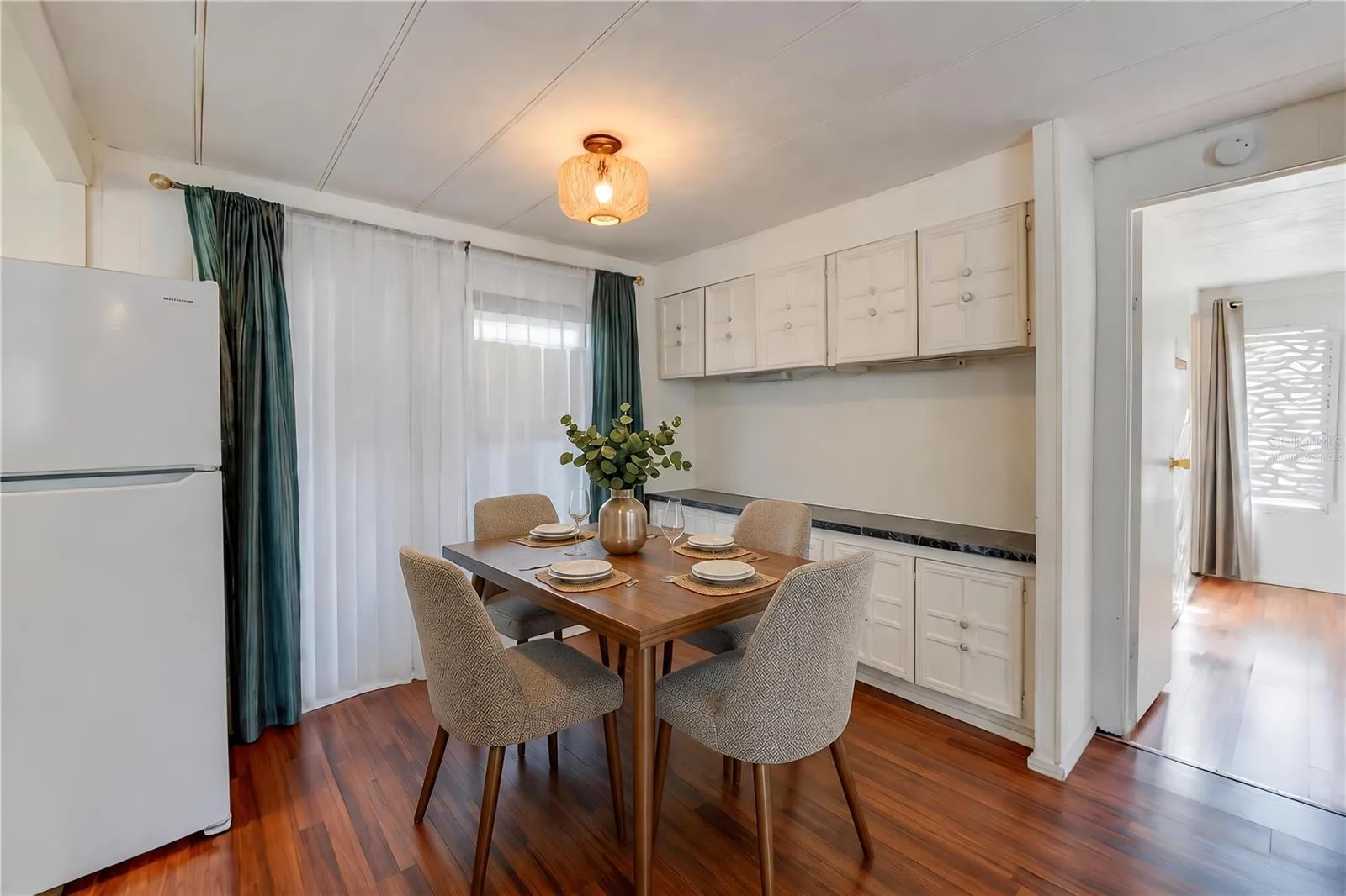 Virtually Staged - Dedicated dining space features extensive built-in cabinetry and countertop space, with a large window bringing natural light into the room.