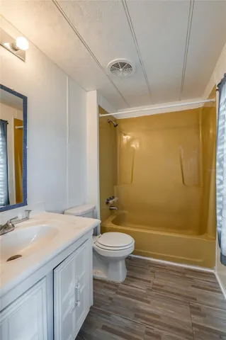 Full bathroom features a tub/shower combination, vanity with storage, and a window providing natural light.