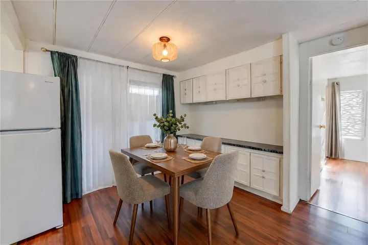 Virtually Staged - Dedicated dining space features extensive built-in cabinetry and countertop space, with a large window bringing natural light into the room.