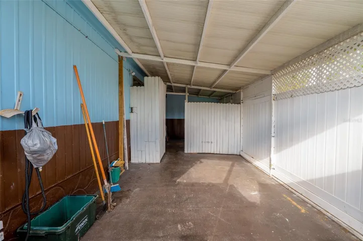 Extended carport area offers ample sheltered space with privacy panels and convenient access to the home.