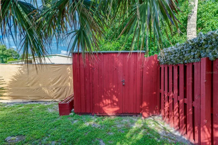 Freestanding storage shed provides a dedicated space for lawn equipment, tools, and other outdoor items, with convenient access from the backyard.