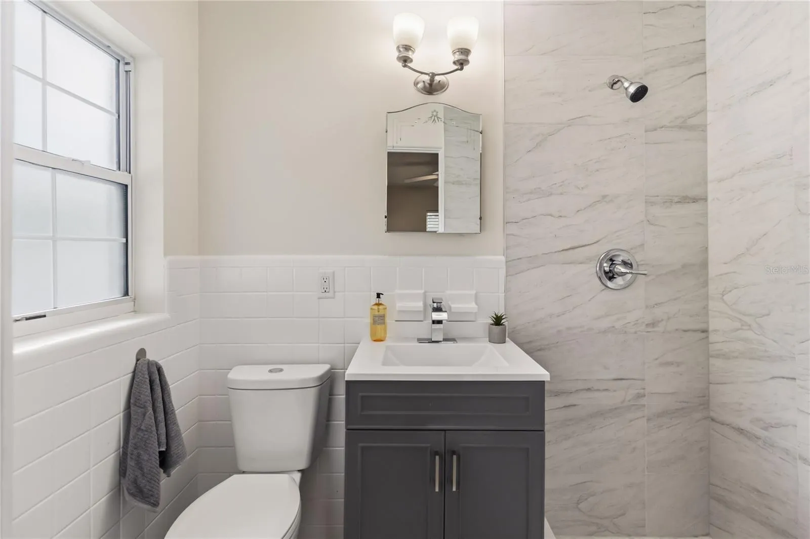 Primary ensuite has a nice Vanity, new light fixture new water storage with large shower