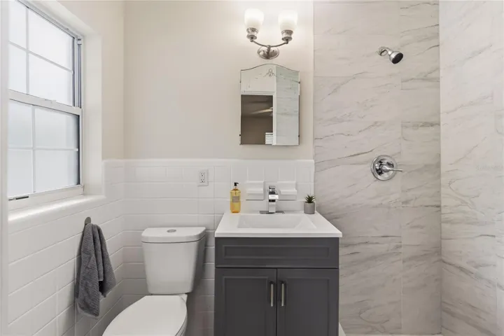 Primary ensuite has a nice Vanity, new light fixture new water storage with large shower