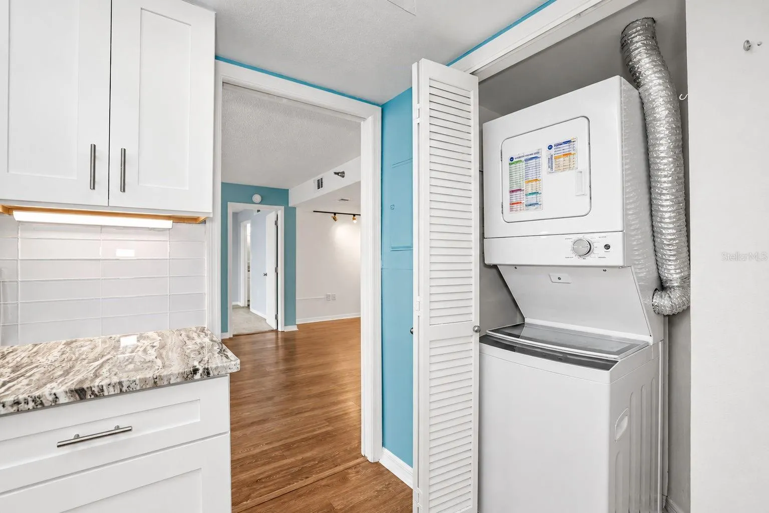 Notice pretty glass subway tiles and Washer Dryer conveniently located in the unit