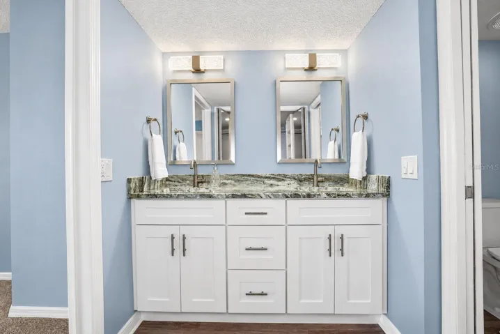 Primary Bathroom, newly updated with double sink shaker cabinet vanity with soft close drawers, lighting, mirrors and paint.