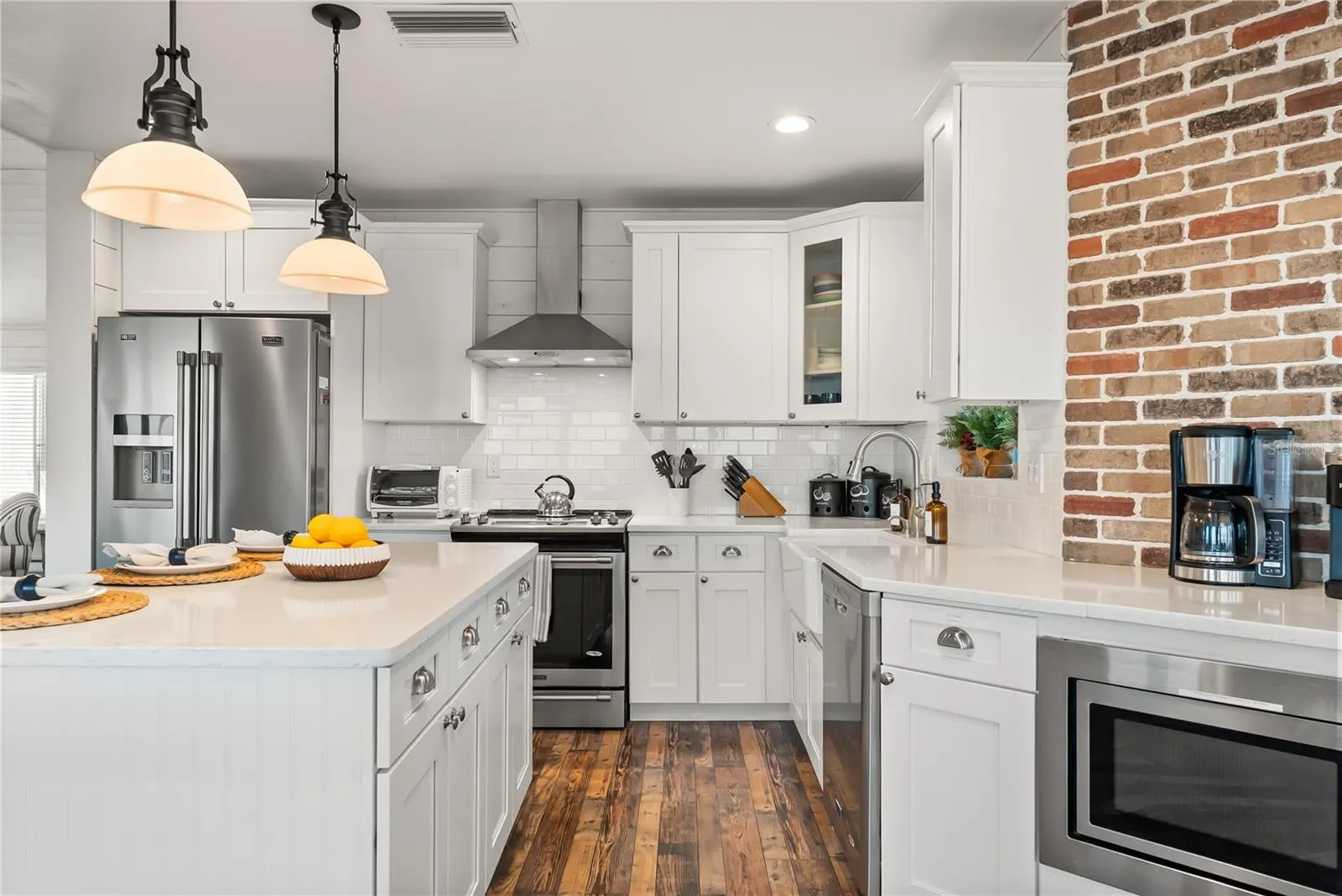 Spacious eat-in kitchen with stainless steel appliances, quartz countertops, breakfast bar seating, and beautiful ocean views—an inviting setting for casual meals and gathering.