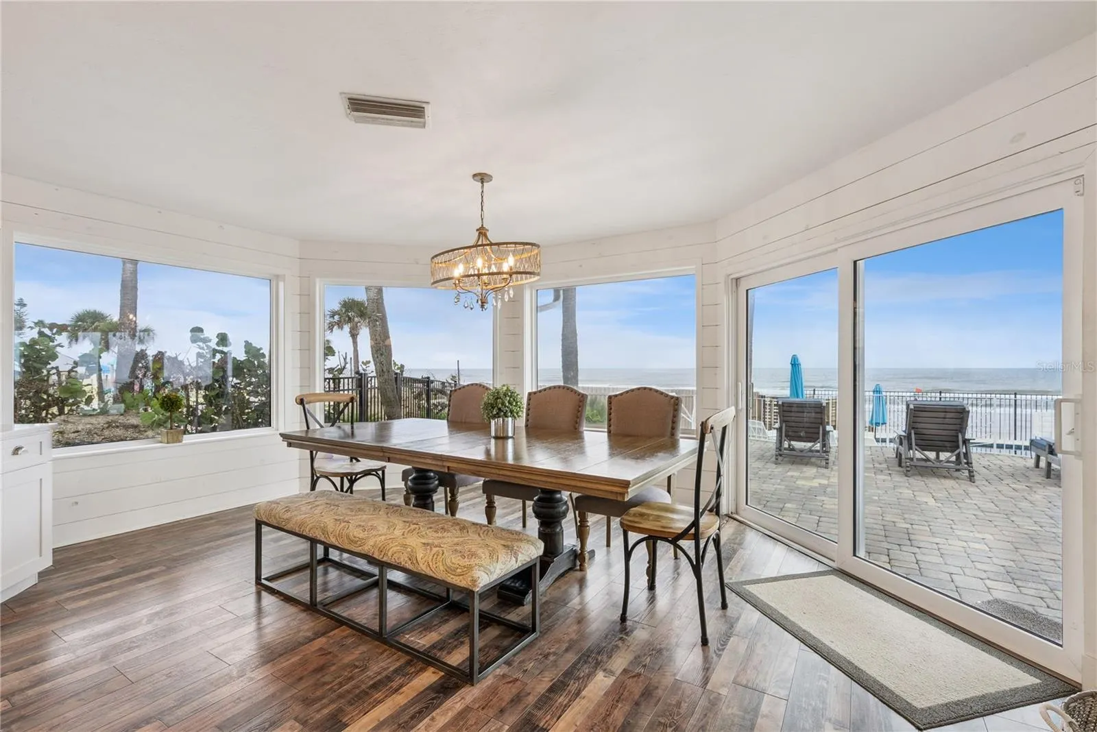 Spacious eat-in kitchen with stainless steel appliances, quartz countertops, breakfast bar seating, and beautiful ocean views—an inviting setting for casual meals and gathering.