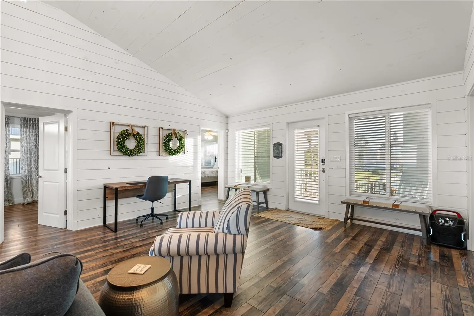 Sweeping Atlantic views take center stage in this bright family room, complemented by coastal furnishings and luxury vinyl plank flooring.