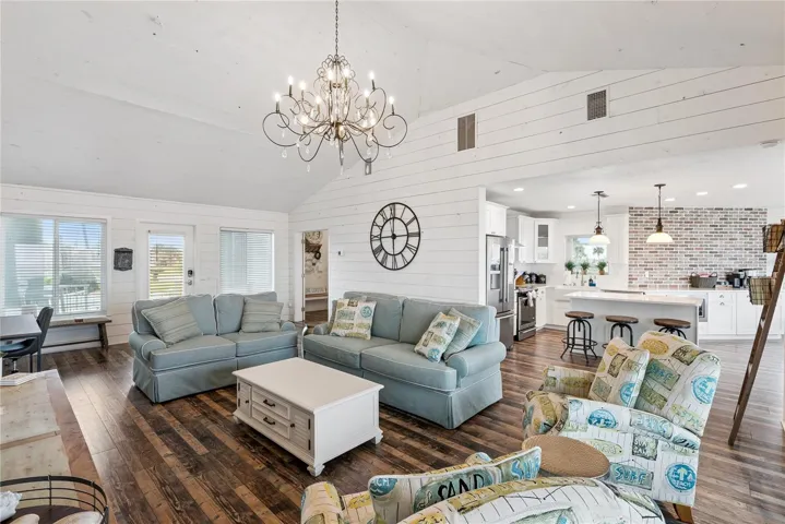 Sweeping Atlantic views take center stage in this bright family room, complemented by coastal furnishings and luxury vinyl plank flooring.
