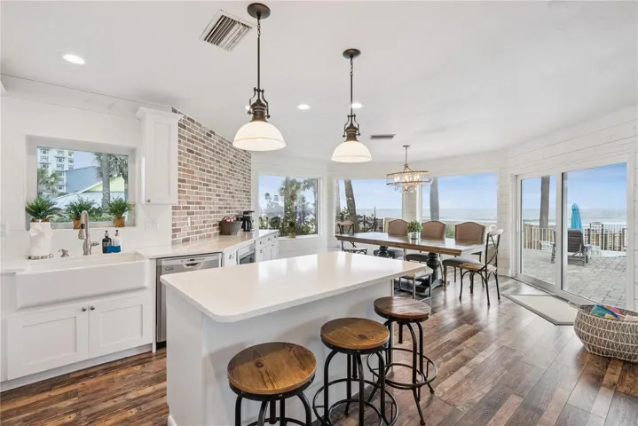 Spacious eat-in kitchen with stainless steel appliances, quartz countertops, breakfast bar seating, and beautiful ocean views—an inviting setting for casual meals and gathering.