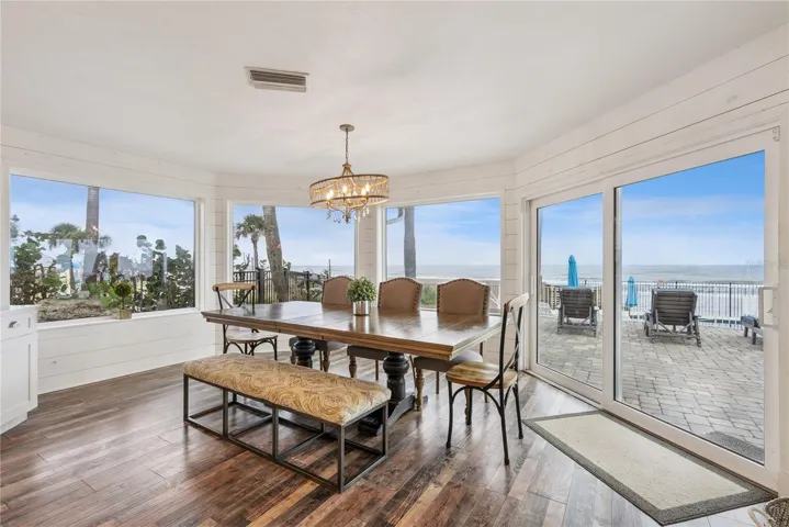 Spacious eat-in kitchen with stainless steel appliances, quartz countertops, breakfast bar seating, and beautiful ocean views—an inviting setting for casual meals and gathering.