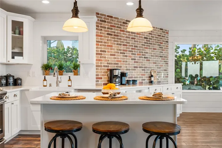 Spacious eat-in kitchen with stainless steel appliances, quartz countertops, breakfast bar seating, and beautiful ocean views—an inviting setting for casual meals and gathering.