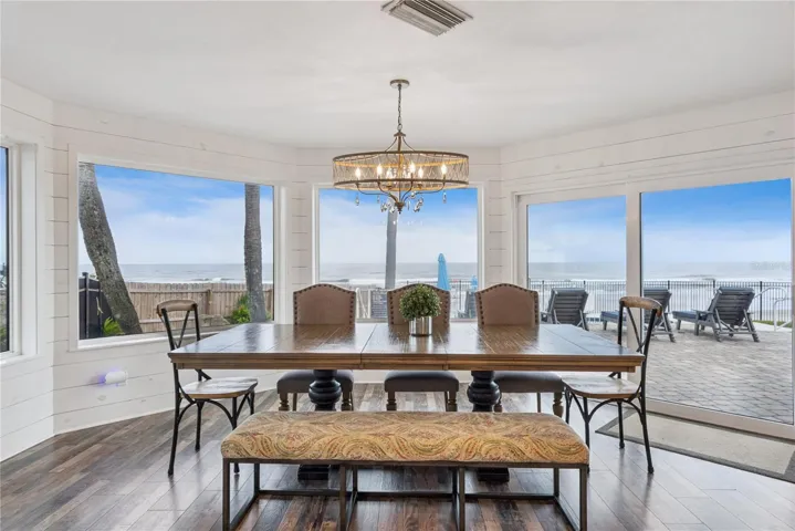 Spacious eat-in kitchen with stainless steel appliances, quartz countertops, breakfast bar seating, and beautiful ocean views—an inviting setting for casual meals and gathering.
