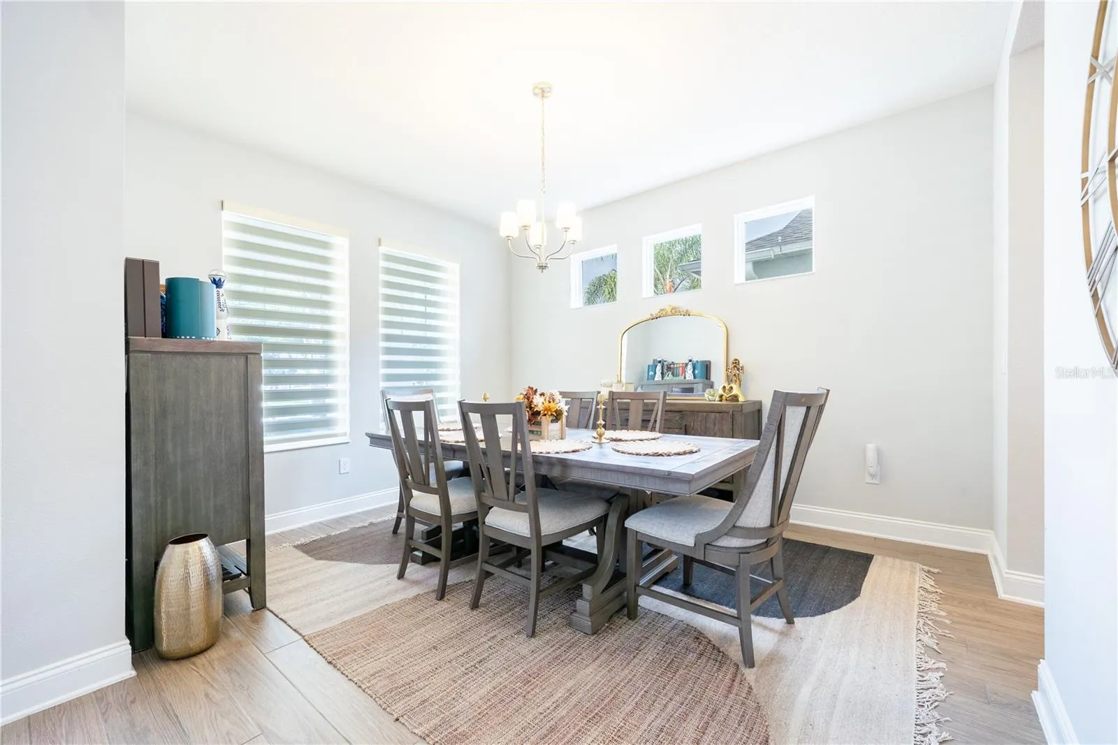 Elegant dining room with abundant natural light and a classic chandelier.