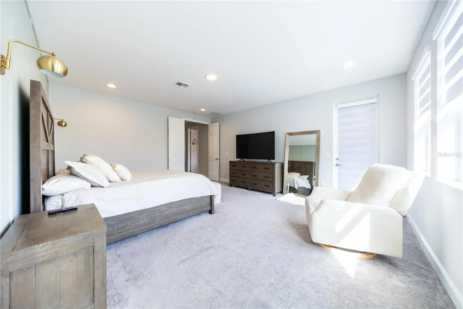 Spacious primary bedroom with a sitting area, double-door entry, and direct porch access.